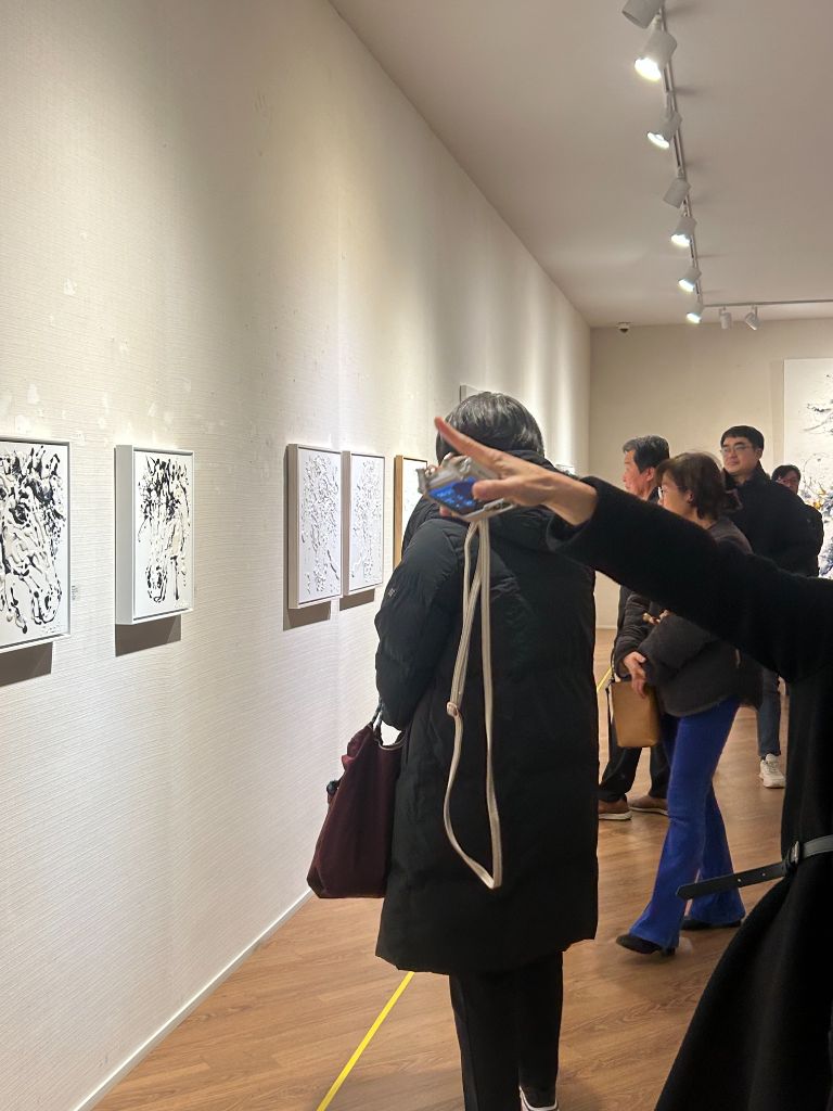 벽면 작품을 함께 보는 관람객